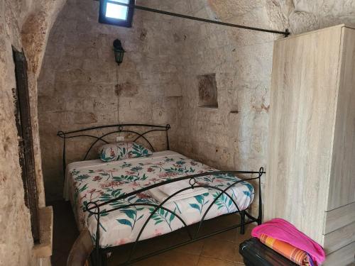 - une chambre avec un lit dans un mur en pierre dans l'établissement Trullo LuCe Ostuni, à Ostuni
