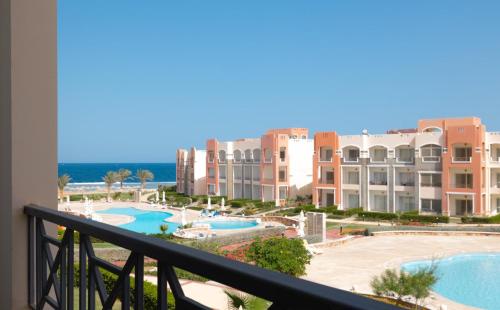 a view of the pool from the balcony of a resort at Oyster Bay Beach Suites in Abu Dabab