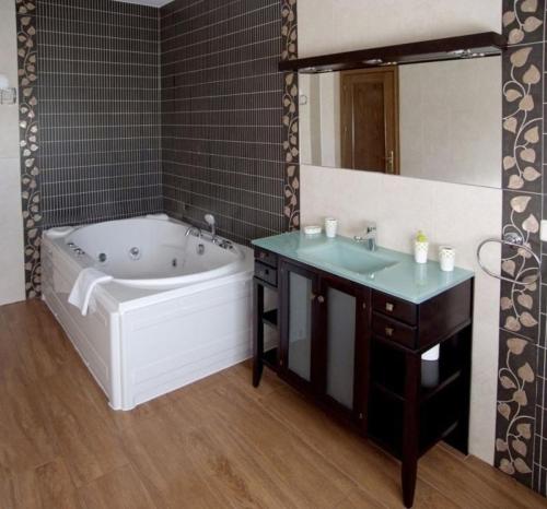y baño con bañera, lavabo y espejo. en Ferienhaus in Gálvez mit Offenem Kamin, en Gálvez