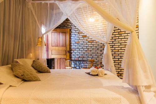 a bedroom with a bed with curtains and stuffed animals on it at Villa Malie in Santo Amaro