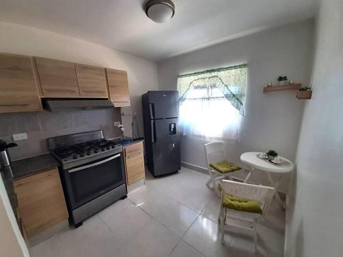 a kitchen with a stove and a refrigerator and a sink at Comfortable Apartament in Los Paredones