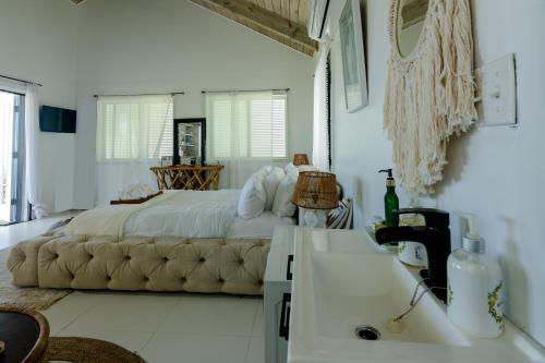 a bedroom with a large bed and a sink at Tulixx Cayman Villa 