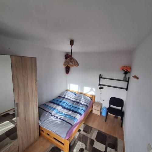 1 dormitorio pequeño con 1 cama y 1 silla en Domek Zawoja en Zawoja