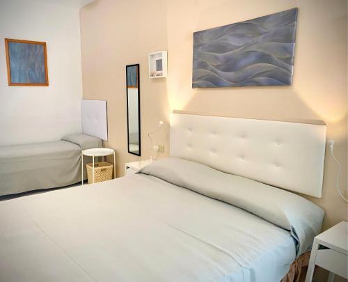 a bedroom with a white bed and a painting on the wall at Hotel Lorenza B&B e Mini Suite in Cavoli