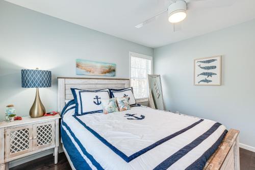 a bedroom with a bed with blue and white sheets at Long Branch Beach House with Private Hot Tub! in Long Branch