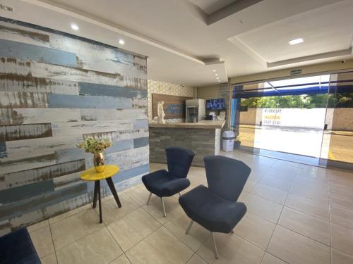 a lobby with a table and two chairs and a counter at Hotel Pousada dos Anjos in João Pessoa