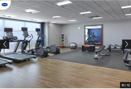 a gym with several treadmills and machines in a room at Hampton Inn & Suites Fultondale 