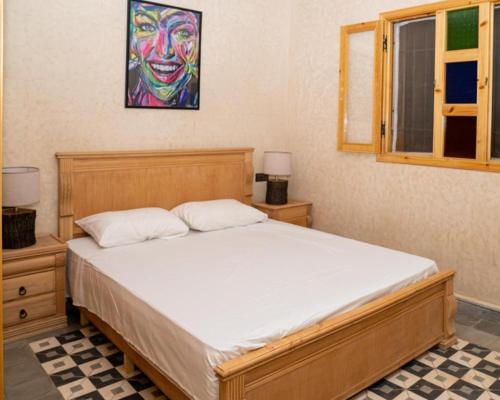 ein Schlafzimmer mit einem Bett mit einem Gemälde eines Clowns in der Unterkunft Villa Dar Sarah (private pool and hammam, piscine privée et hammam) in Agadir