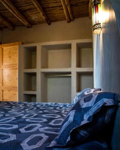 a bedroom with a bed with a blue comforter at Villa Dar Sarah (private pool and hammam, piscine privée et hammam) in Agadir