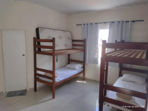 a room with two bunk beds and a window at Goiânia Hostel. in Lucas do Rio Verde