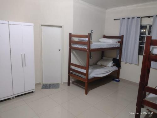 a room with two bunk beds and a closet at Goiânia Hostel. in Lucas do Rio Verde