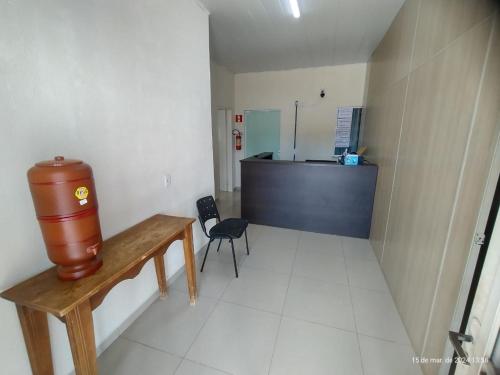 a room with a table and a counter in a room at Goiânia Hostel. in Lucas do Rio Verde