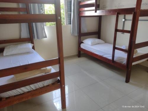 a room with three bunk beds in a room at Goiânia Hostel. in Lucas do Rio Verde