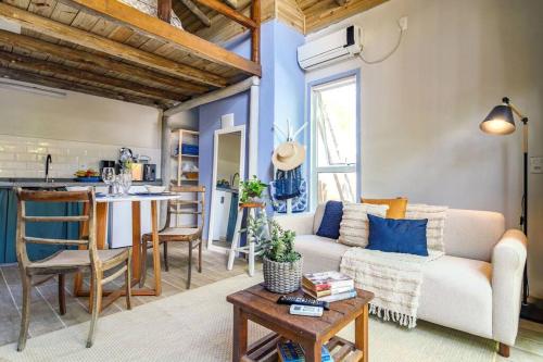 a living room with a couch and a table at Chalé e lofts charmosos pertinho de praia in Florianópolis