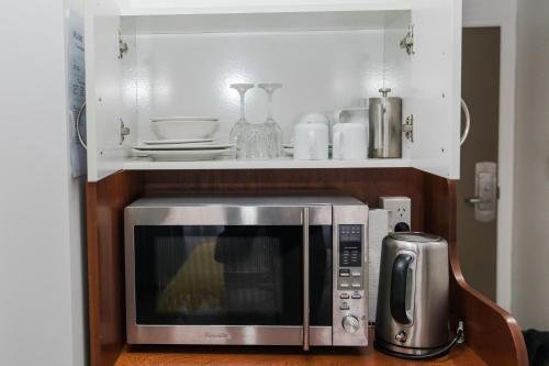 a kitchen with a microwave and a silver appliance at A City Stay Holiday on Queen Street in Auckland
