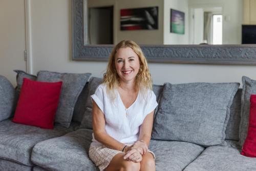 a woman sitting on top of a couch at A City Stay Holiday on Queen Street in Auckland