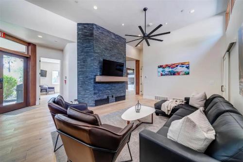 a living room with a black leather couch and a fireplace at LaFave Luxury Rentals at Zion in Springdale
