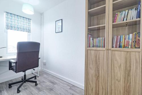 a office with a chair and a desk and book shelves at High view house, 3 bed flat, Number 41A in Walton-on-the-Naze