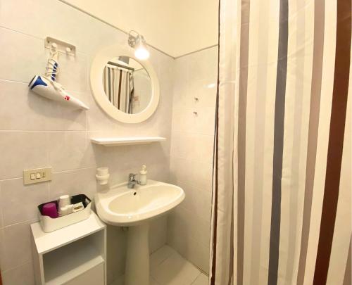 a white bathroom with a sink and a mirror at Hotel Lorenza B&B e Mini Suite in Cavoli