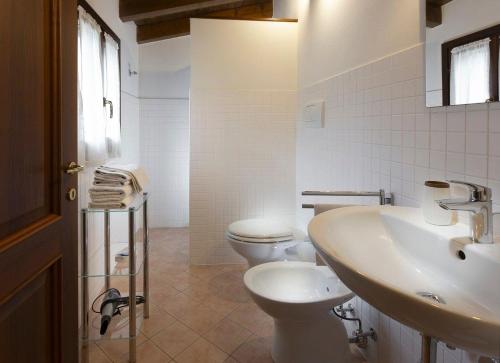 a white bathroom with a toilet and a sink at Appartement in Scandiano mit Privatem Parkplatz in Scandiano