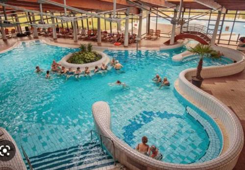 a group of people in a large swimming pool at Revans teázó apartman- belváros in Pápa