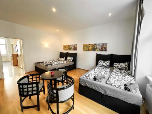 2 Betten in einem Zimmer mit Tisch und Stühlen in der Unterkunft W Apartment - Brigittenau Area MM10 in Wien
