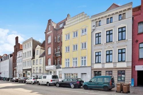 a row of buildings on a city street with cars parked at Ferienwohnung für 2 Personen ca 55 qm in Lübeck, Ostseeküste Deutschland Lübecker Bucht in Lübeck