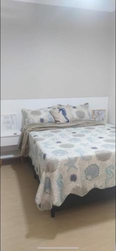 a bedroom with a bed with a blanket on it at Mar Doce Lar in Santos