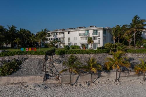 a building on the beach with palm trees at Hotel Dos Playas Faranda Cancún in Cancún