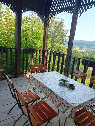 uma mesa e cadeiras num alpendre com vista em Country house pivnica Milic Rogljevo em Rogljevo