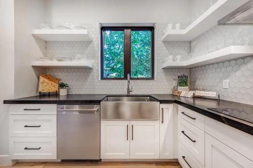 a kitchen with a stainless steel sink and white cabinets at LaFave Luxury Rentals at Zion in Springdale