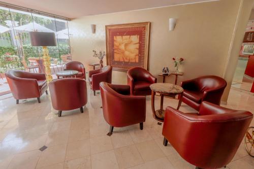 a waiting room with red chairs and a table at Hotel Boutique Runcu Miraflores in Lima