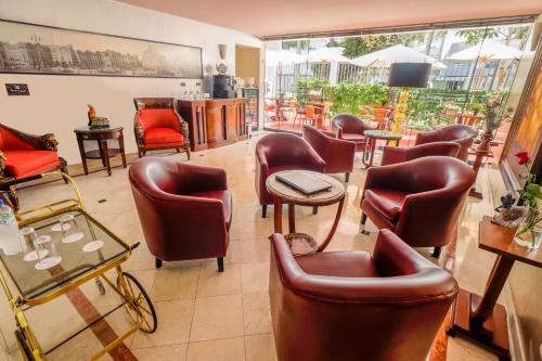 a waiting room with leather chairs and tables at Hotel Runcu Miraflores in Lima