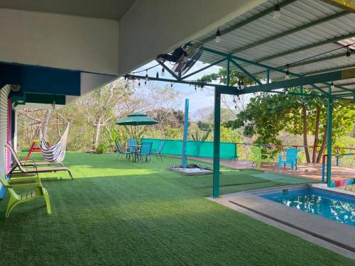 patio con amaca e piscina di Casa de Colores a Puntarenas