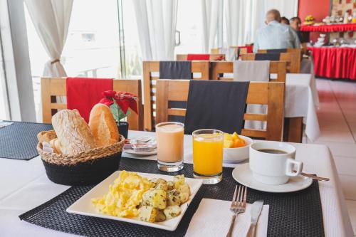 a table with a plate of breakfast food and orange juice at Hotel Boutique Runcu Miraflores in Lima