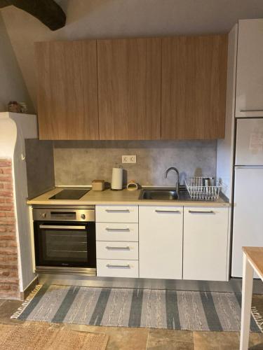 a kitchen with white cabinets and a stove and a sink at Casa do Monte - Esperança in Esperança