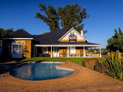 a house with a swimming pool in the yard at Retief Guest Farm in Kroonstad