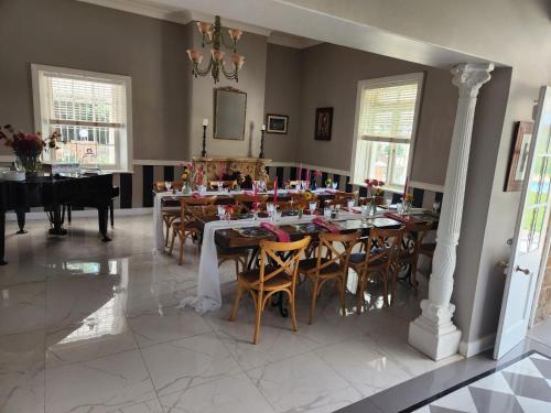 a dining room with a table and chairs and a piano at Retief Guest Farm in Kroonstad