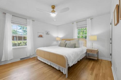 1 dormitorio blanco con 1 cama y 2 ventanas en The Azalea House, en Charleston