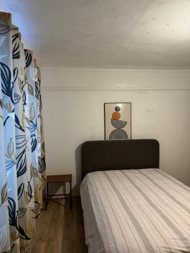 1 dormitorio con 1 cama y una foto en la pared en Double Rooms en Feltham