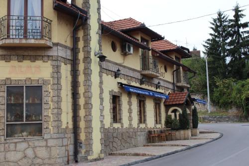 um edifício de pedra ao lado de uma rua em Motel Alas em Banja Luka