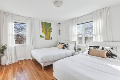2 camas en una habitación blanca con ventanas en Luxury NY Getaway with Free Garage Parking in PRIME Location, en White Plains