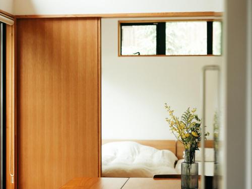 a bedroom with a door leading to a bed at Karuizawa Forest Seasons Villa in Karuizawa