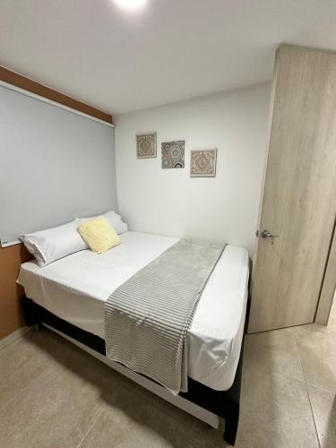 um pequeno quarto com uma cama e uma porta de madeira em Apartamento en Laureles cerca a la 70 y Estadio - 702 em Medellín
