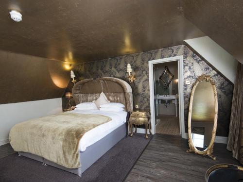 a bedroom with a large bed and a mirror at The Spread Eagle Hotel in Thame