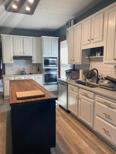 a kitchen with white cabinets and a wooden counter top at Firefly Hills in Beattyville