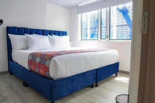 sypialnia z niebieskim łóżkiem z niebieskim zagłówkiem w obiekcie Hotel Sky Blue w mieście Manizales