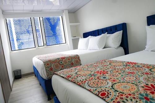 pokój hotelowy z 2 łóżkami i oknem w obiekcie Hotel Sky Blue w mieście Manizales