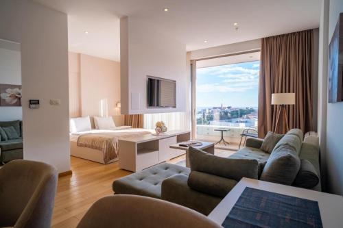 a hotel room with a bed and a living room at Budva Center Suite Old Town Sea Wiev 506 in Budva
