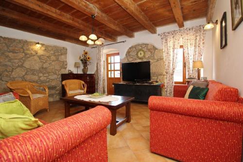 un salon avec deux chaises rouges et une table dans l'établissement Renoviertes Steinhaus mit Garten und Pool ideal für ein erholsamen Urlaub, à Baška